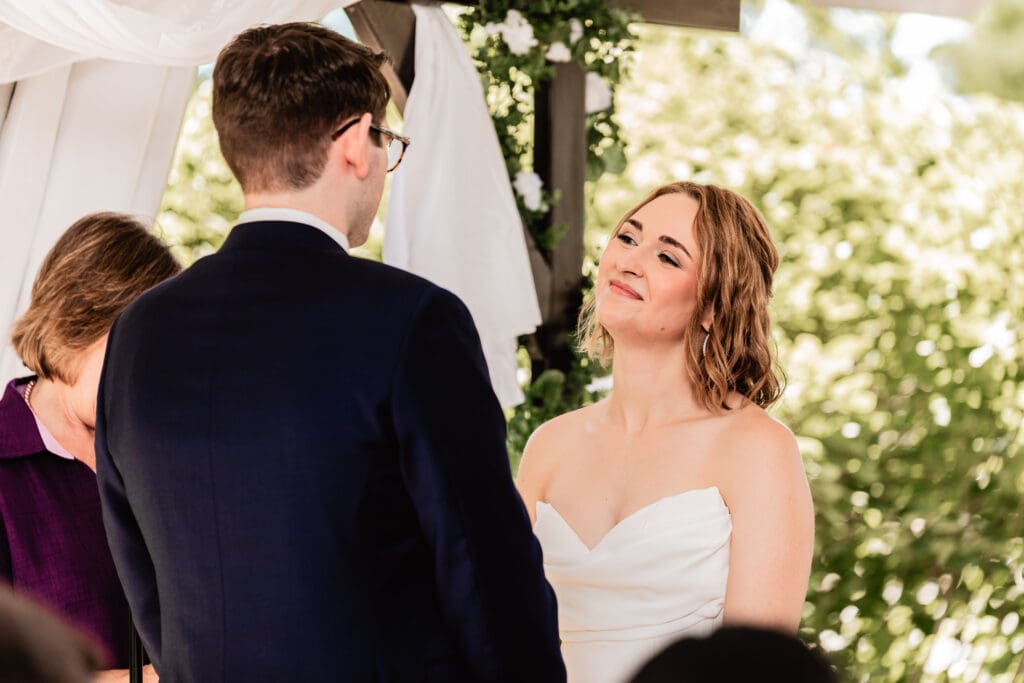 Groom reading vows aloud while standing with his bride at the Schenley Park Welcome Center wedding ceremony