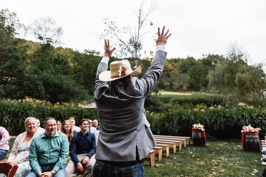 Flower boy throwing petals into the air during ceremony at Hinckston Run Farm