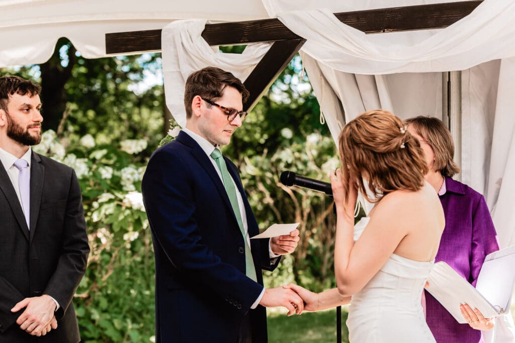 Bride wiping away tears during vows at the Schenley Park Welcome Center wedding ceremony