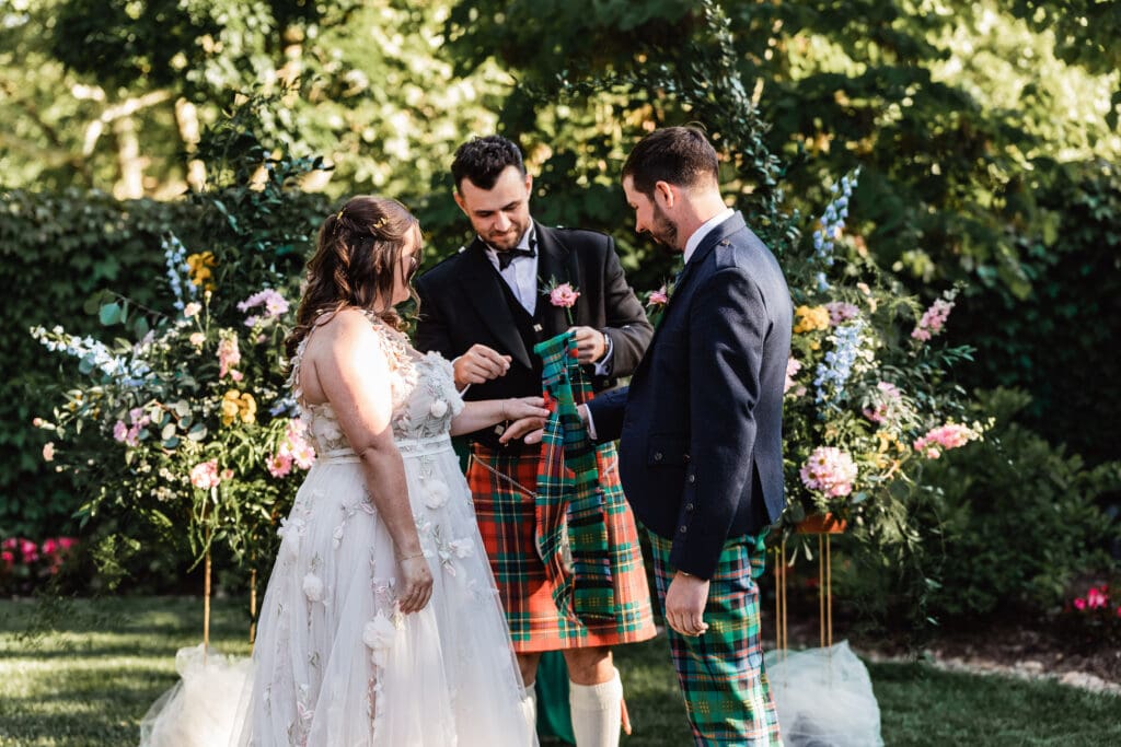 Scottish wedding ceremony with kilts and lace wedding dress in a garden at National Aviary