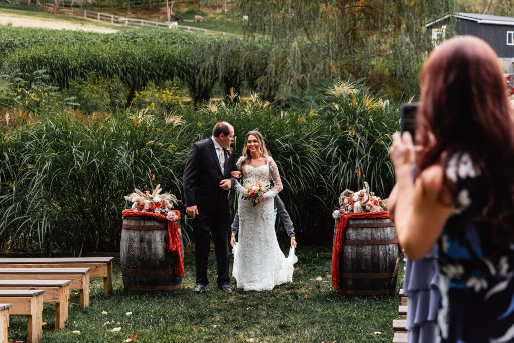 Bride making her entrance at outdoor wedding ceremony at Hinckston Run Farm