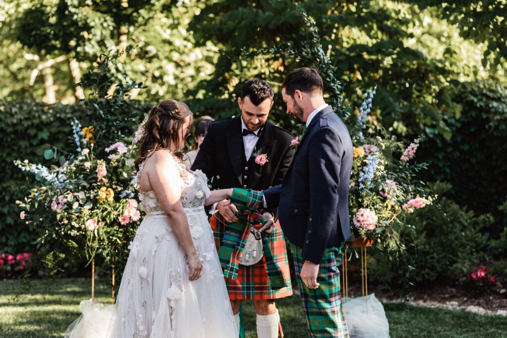 Wedding couple celebrates a Scottish ceremony in a lush garden setting at National Aviary