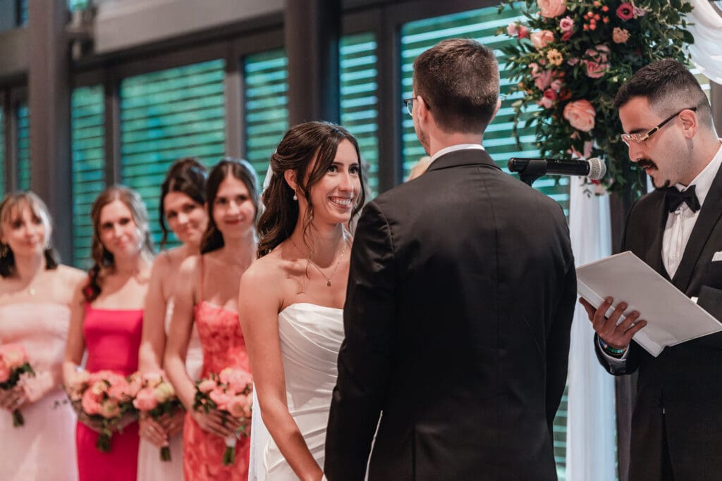 Bride smiling lovingly at her groom during wedding ceremony at the National Aviary