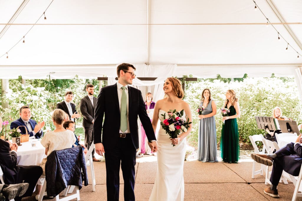 Bride and groom walking back up the aisle after their ceremony at Schenley Park Welcome Center