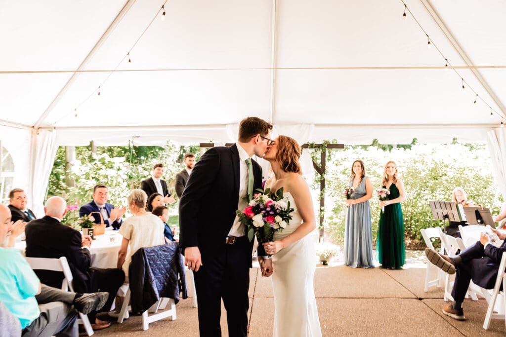 Bride and groom kissing in the aisle during their Schenley Park Welcome Center wedding ceremony