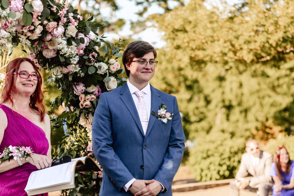 Pittsburgh groom watching his bride walk down the aisle during their wedding ceremony at Phipps Botanical Gardens in Pittsburgh