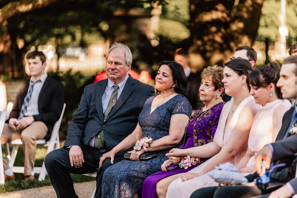 Groom’s family smiling and watching the couple exchange vows at Phipps Botanical Gardens in Pittsburgh