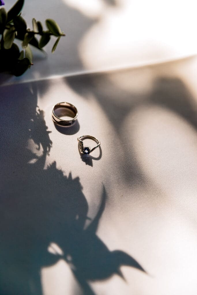 Close-up of wedding rings with the soft shadow of a bridal bouquet cast beside them during a Pittsburgh microwedding