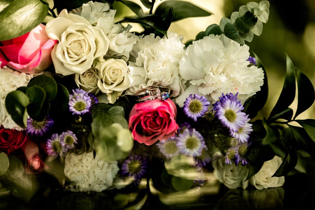 Close-up of wedding rings resting on bouquet flowers at Schenley Park Welcome Center
