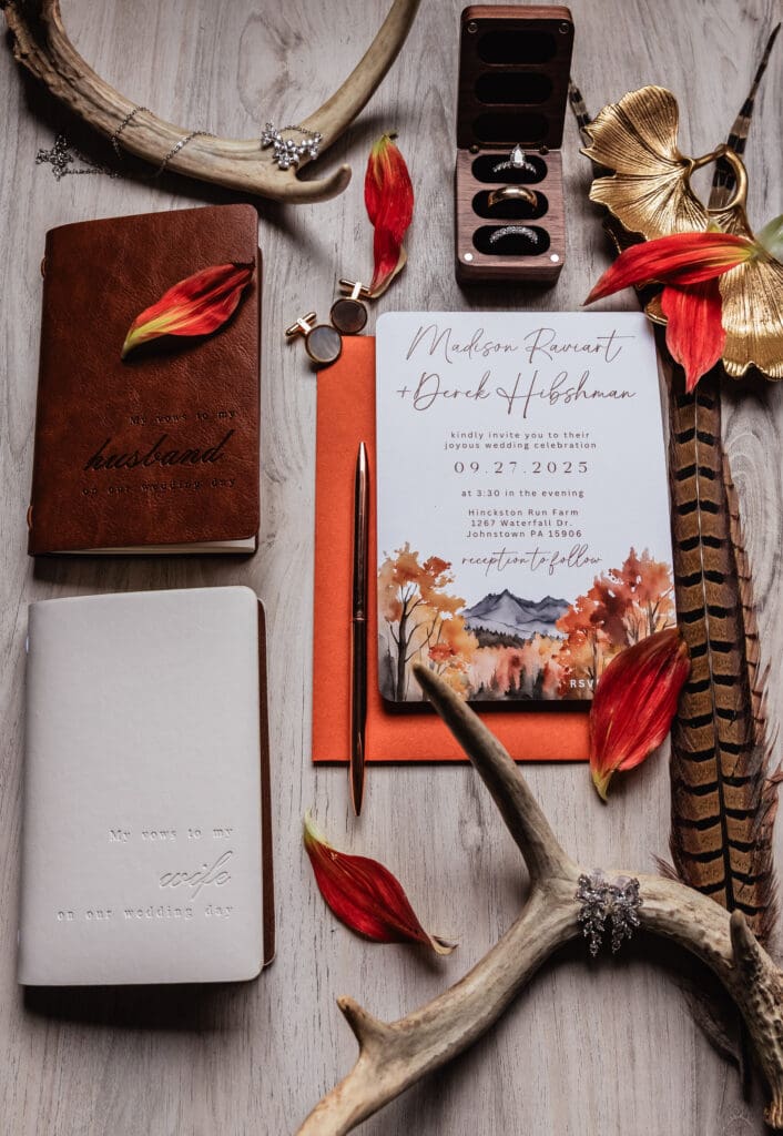 Wedding invitations with leather vow books and autumn leaves at Hinckston Run Farm
