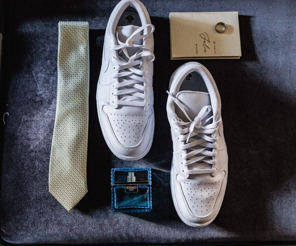 Wedding detail flat lay featuring groom’s shoes, tie, and vows in the Willowbrook bridal suite in Volant, Pennsylvania