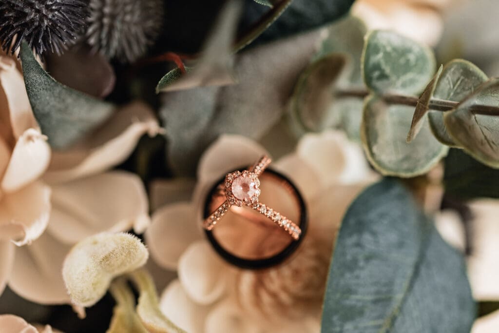 Close-up of wedding bands arranged on sola flowers at Pinehall at Eisler Farm fall wedding