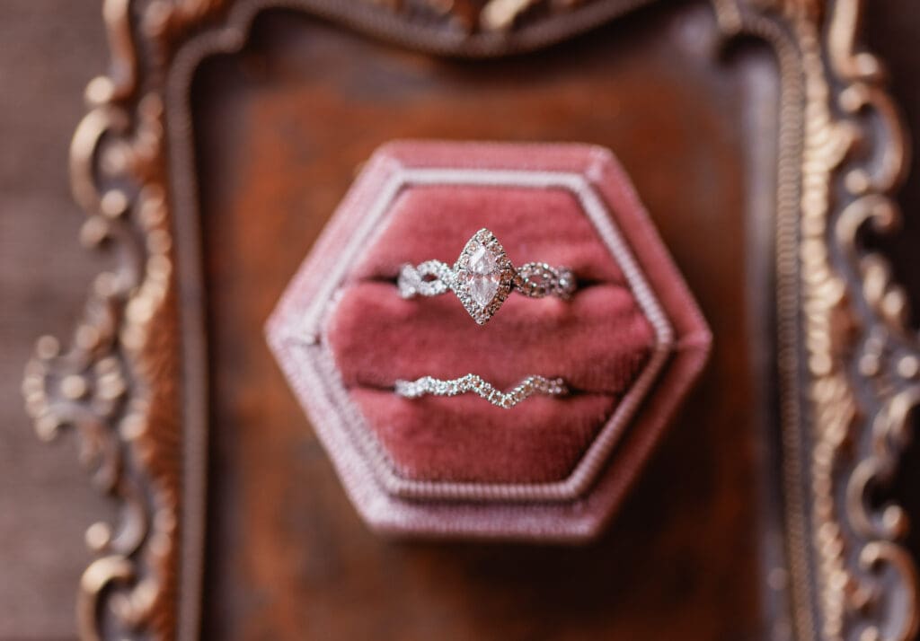 Close up of bride’s engagement ring and wedding band in pink ring box at The Gathering Place at Darlington Lake
