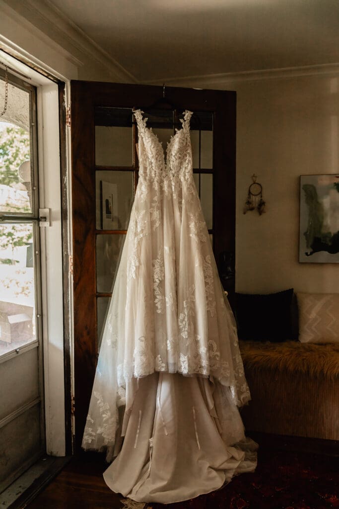 Bride’s wedding dress arranged and hanging on a multi-paned door at a Pittsburgh Phipps Botanical Gardens wedding