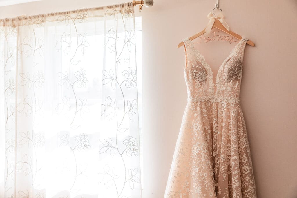 Bride’s wedding dress displayed on personalized last name hanger at Pinehall at Eisler Farm