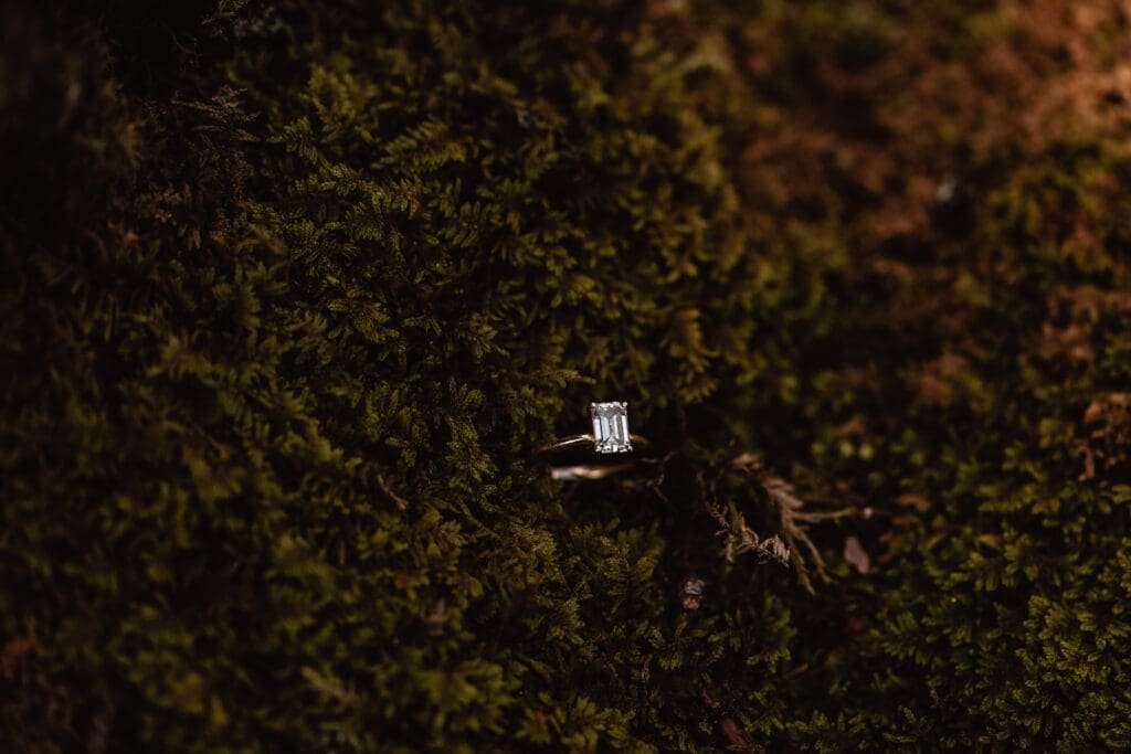 Engagement ring resting in soft green moss during a Coopers Rock State Park engagement session