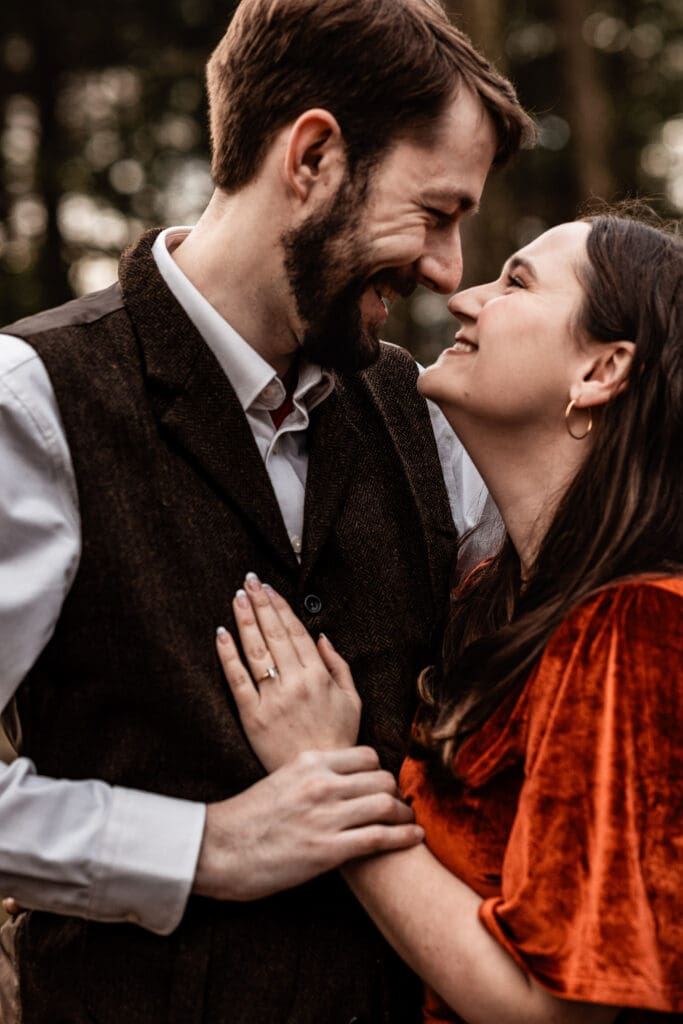 Engaged couple hugging closely on the overlook at Coopers Rock State Park in West Virginia during a windy engagement session