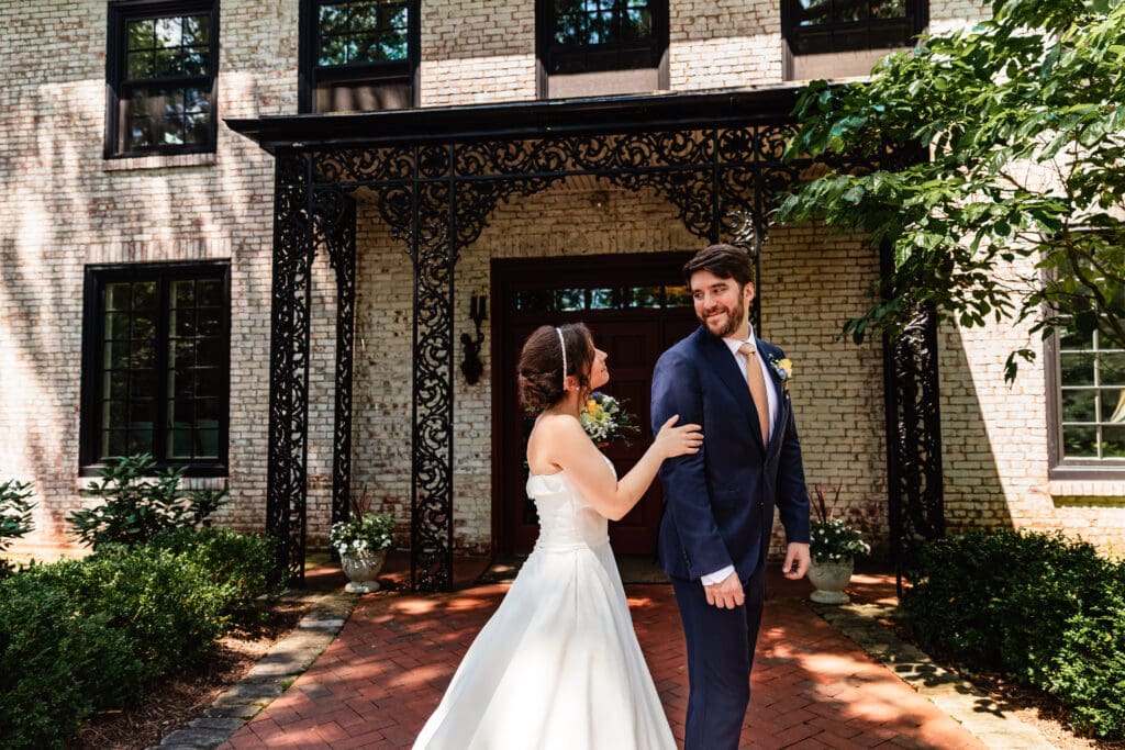 Newlyweds sharing intimate first look in lush garden courtyard at Succop Nature Park