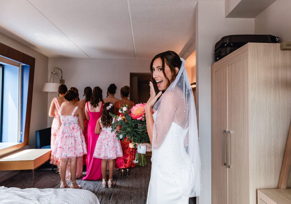 Bride revealing wedding dress to bridesmaids during first look at the National Aviary