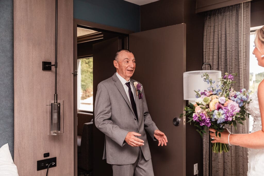 Grandfather reacts with joy during first look with his granddaughter at Pittsburgh Airport Marriott wedding