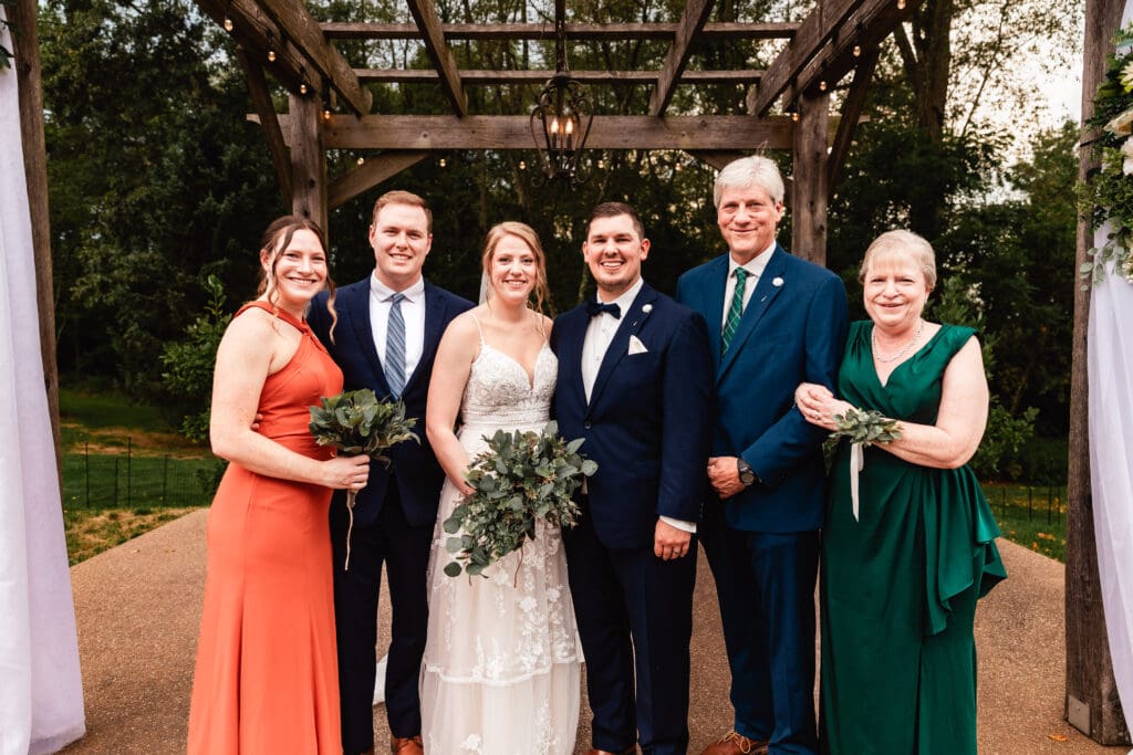 Formal wedding portrait under a wooden pergola at The Barn at Ever Thine in Butler County, Pennsylvania