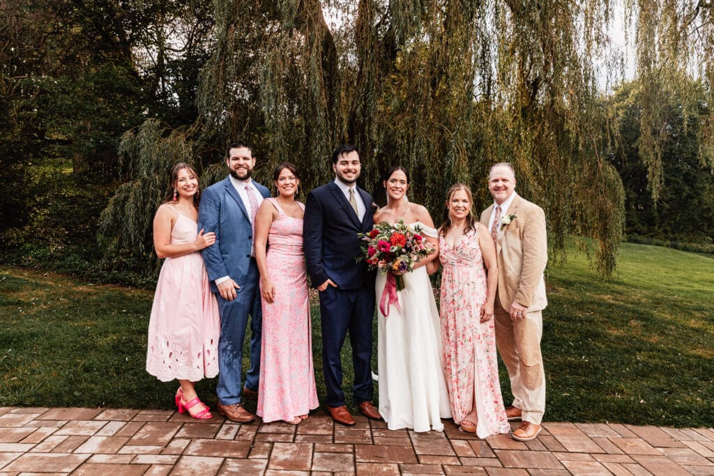 Pittsburgh bride and groom smiling with family members during portraits at Willowbrook wedding in Volant, PA