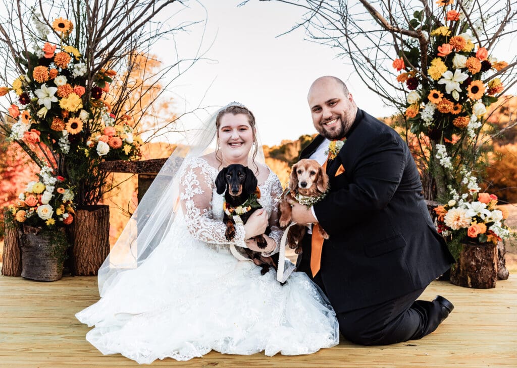 Bride and groom pose with their two dogs during formal portraits at fall Ridgemont Farm wedding in Beaver County