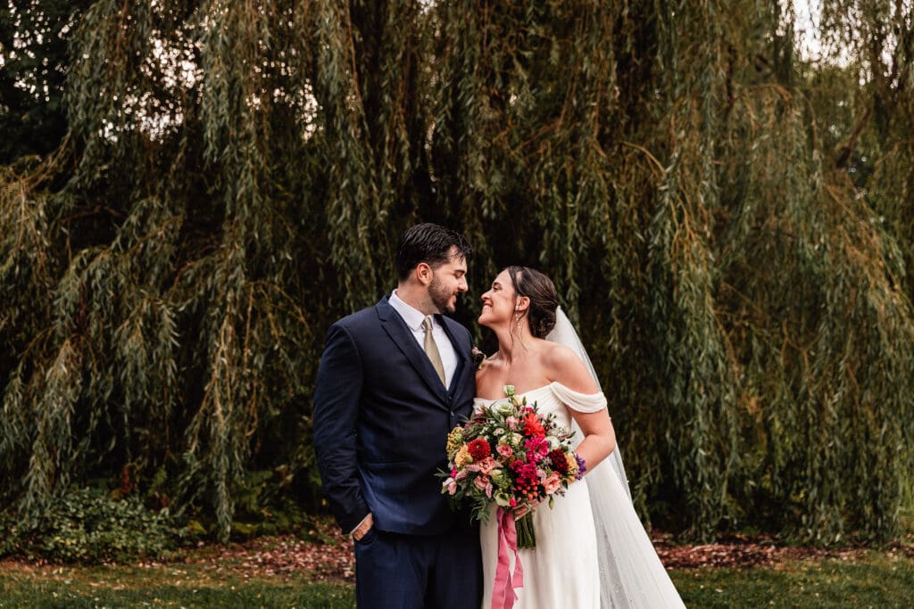 Bride and groom share a loving look during formal family portraits at Willowbrook in Volant, Pennsylvania