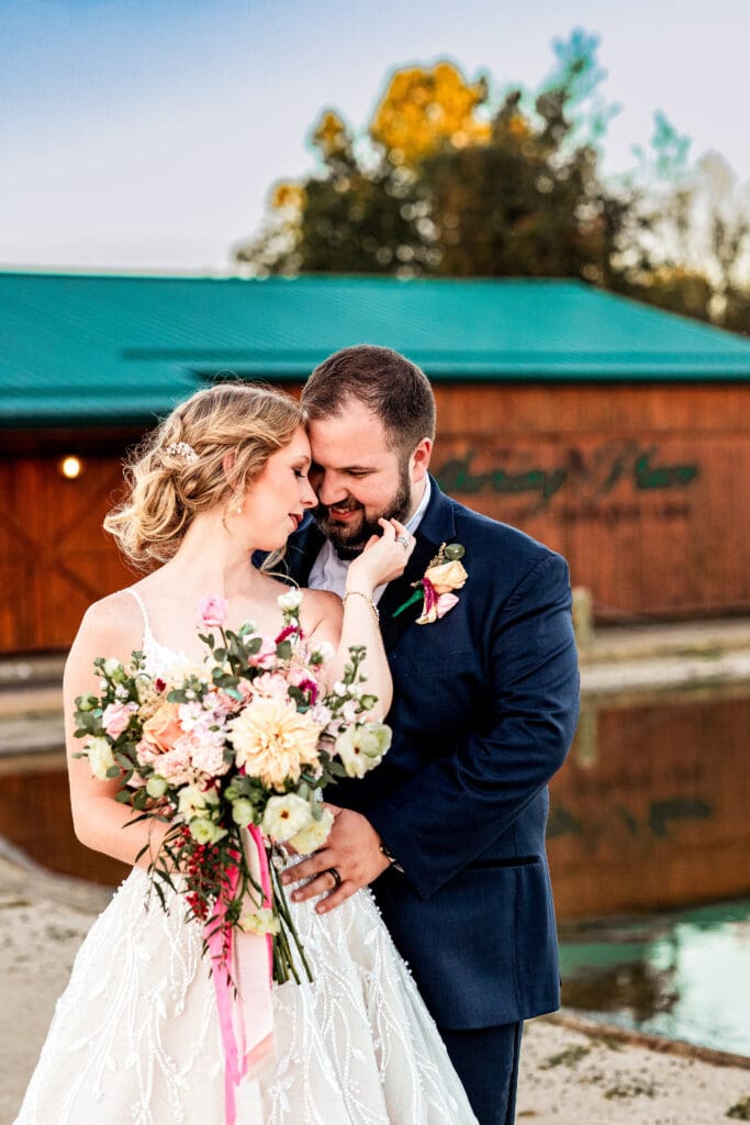 Pittsburgh wedding couple share a quiet moment near water during portraits at The Gathering Place at Darlington Lake