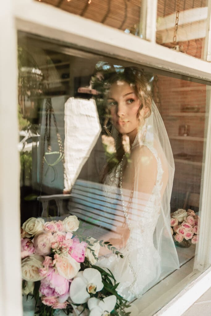 Bride staring thoughtfully out a window prior to her Phipps Botanical Gardens wedding in Pittsburgh