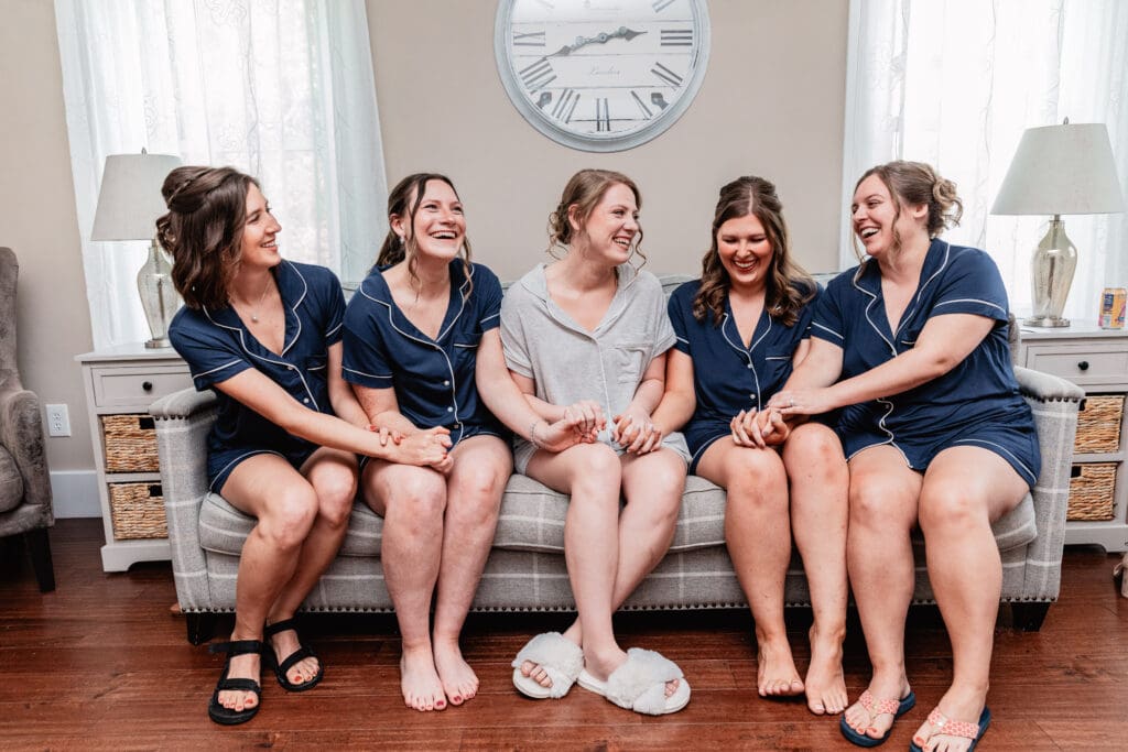 Bride and bridesmaids sharing a quiet moment together in the bridal suite at The Barn at Ever Thine in Butler County, PA