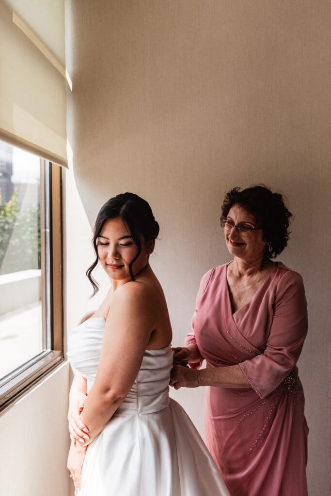 Bride shares a touching moment with loved one by a window at Sheraton Station Square