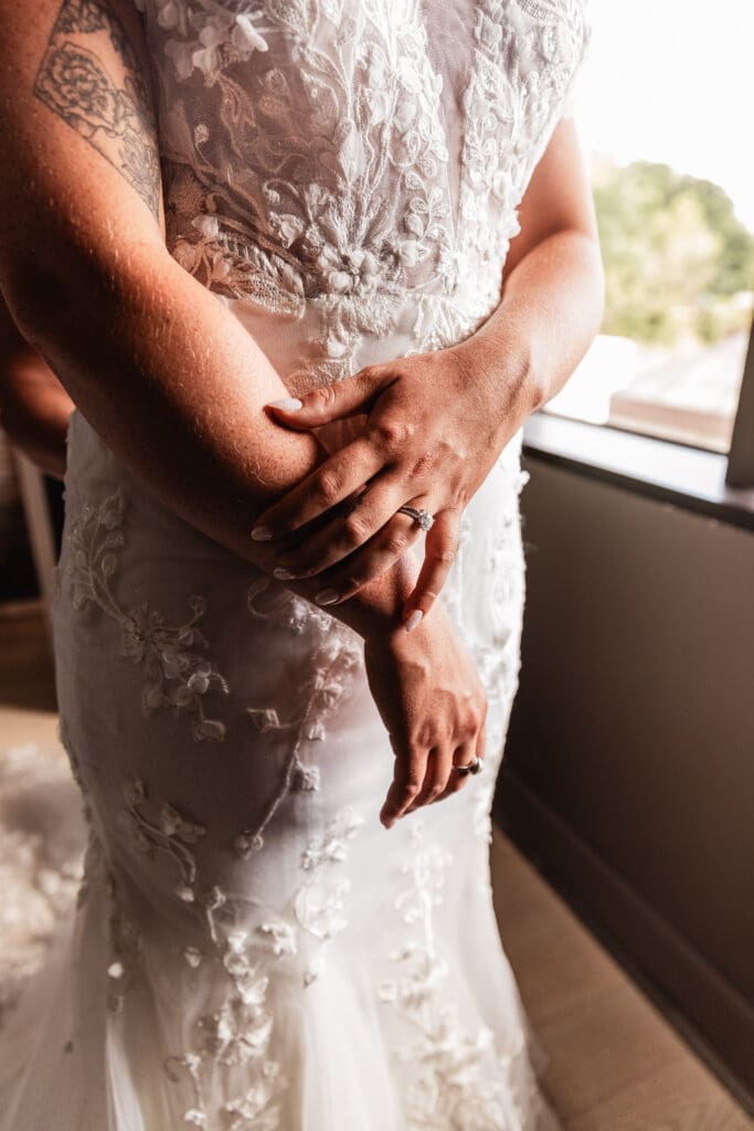 Close up of bride’s rings on her hands as she is helped into her dress at Pittsburgh Airport Marriott