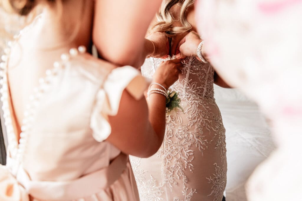 Bride being helped into her wedding dress by her mother and daughter before her courthouse wedding