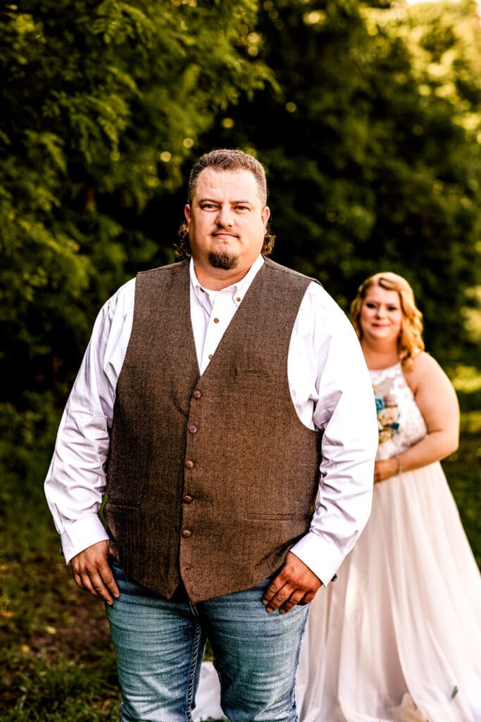 Groom standing in a field at his family farm in Monongahela, PA while waiting for his bride during their first look
