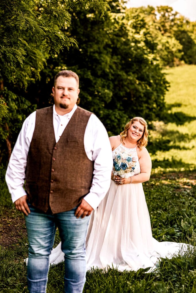 Bride peeking around her groom as he waits for their first look at a family farm wedding in Monongahela, Pennsylvania