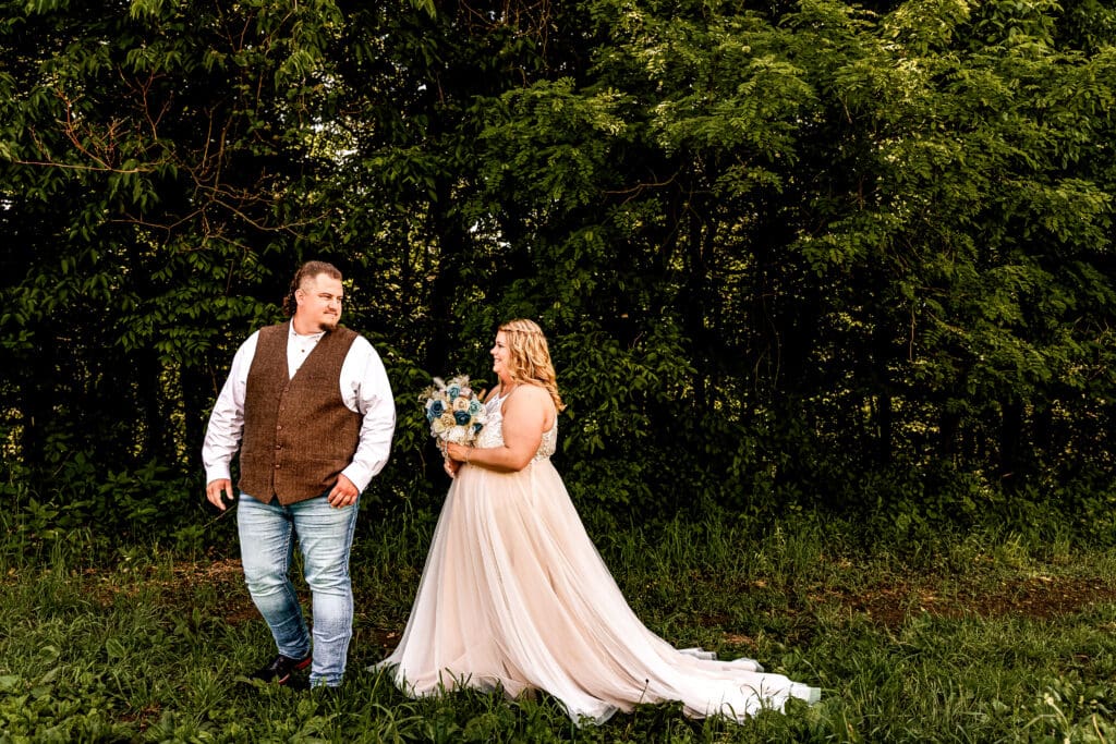 Bride and groom embracing during their first look in a field at their family farm in Monongahela, PA