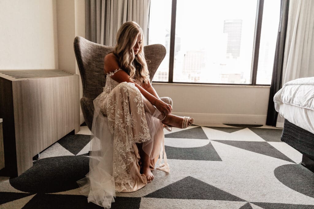 Bride putting on her wedding shoes before her Allegheny County Courthouse ceremony