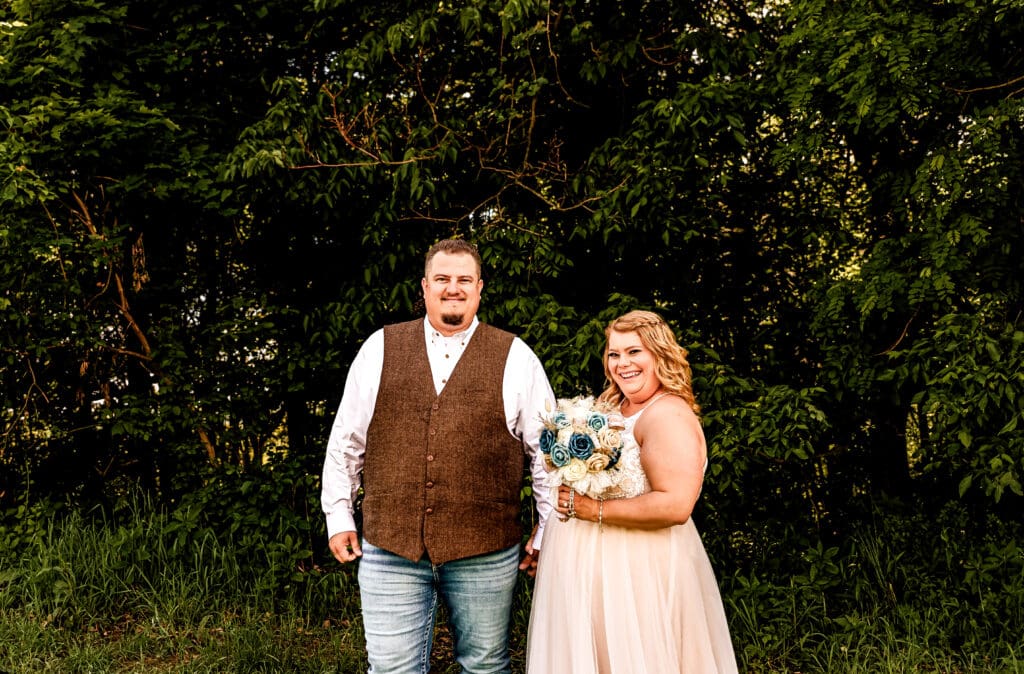 Bride and groom posing together in a field after their first look at a family farm wedding in Monongahela, PA