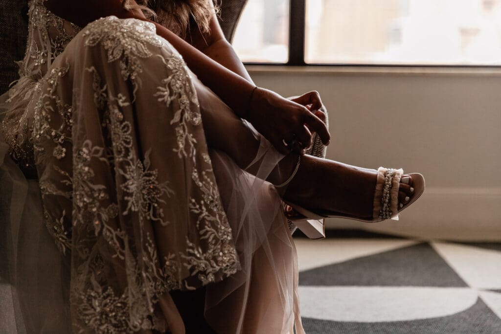 Close up of bride putting on her wedding shoes before her Allegheny County Courthouse ceremony