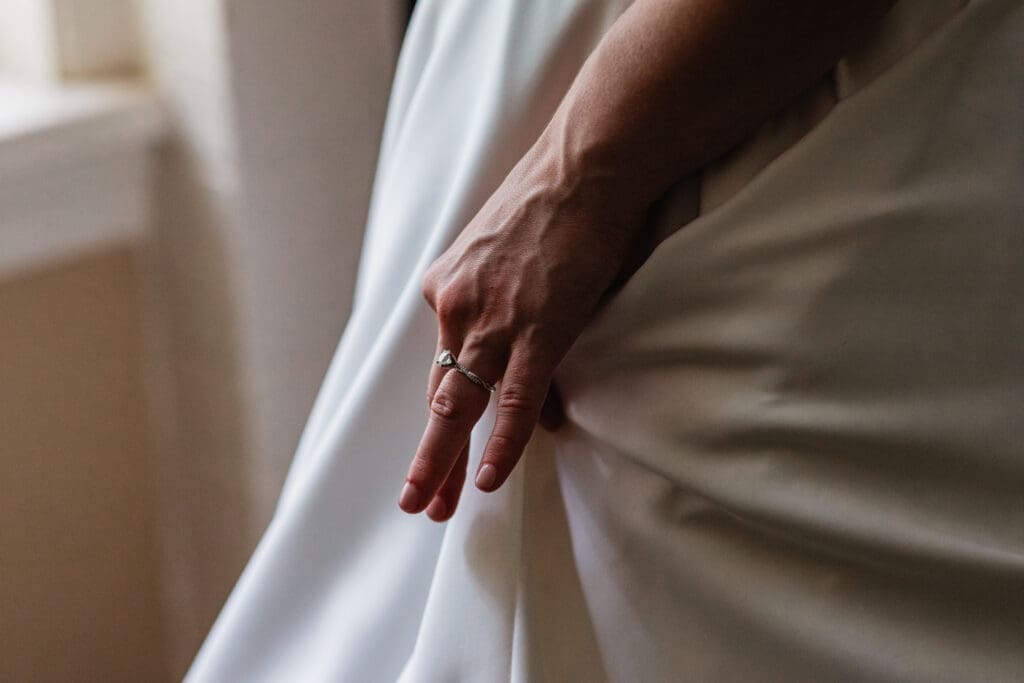Close-up of bride holding wedding dress and engagement ring at Succop Nature Park