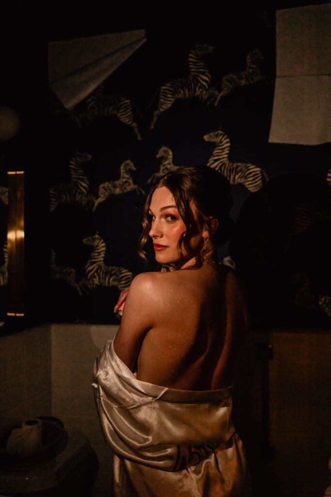 Pittsburgh bride illuminated by cell phone lights showing glitter on her back during pre-ceremony preparations at Phipps Botanical Gardens