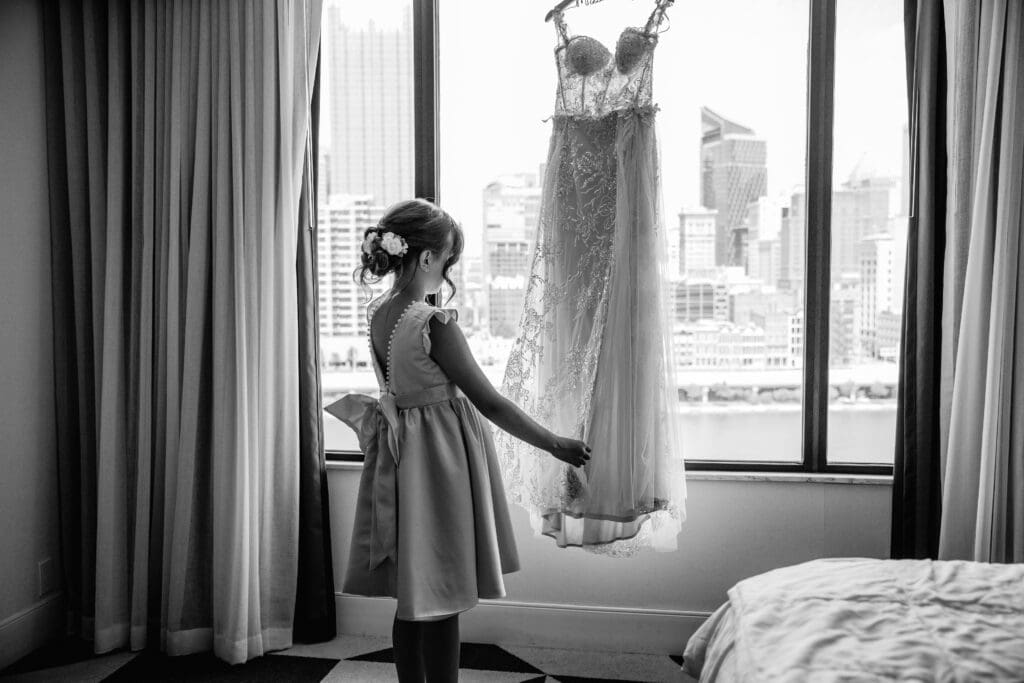 Flower girl standing in front of the bride’s wedding dress during a Pittsburgh courthouse wedding