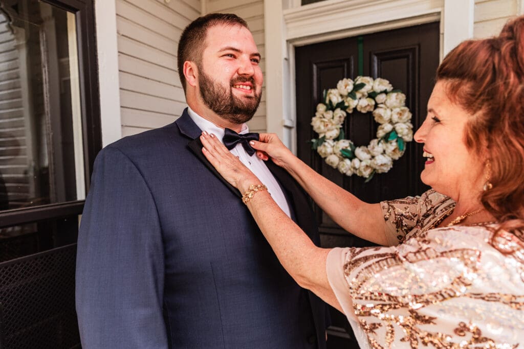 Pittsburgh groom having his bow tie fixed by his mom at The Gathering Place at Darlington Lake