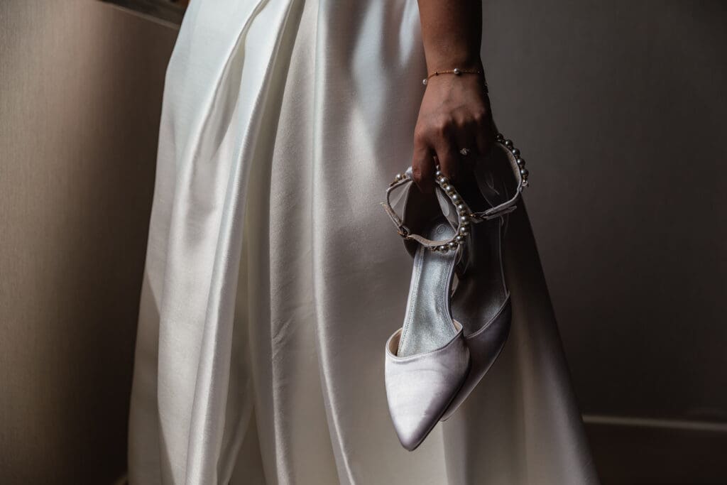 Close up of bride holding wedding shoes during Sheraton Station Square wedding prep