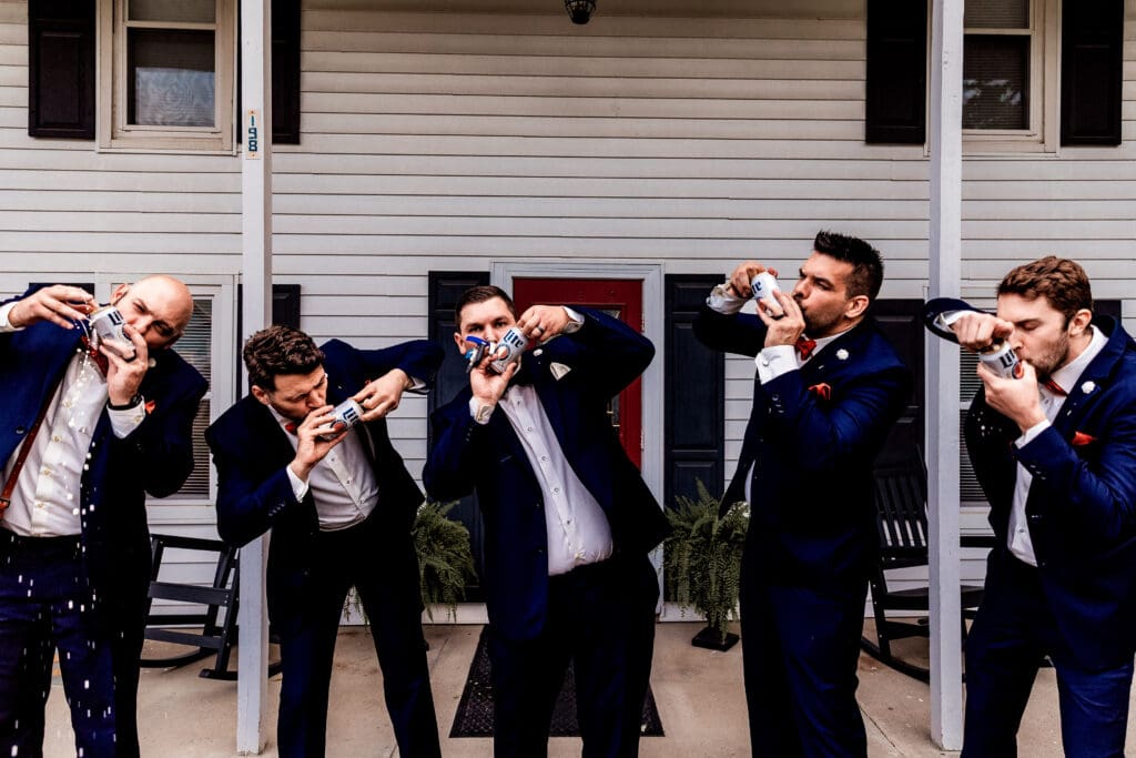 Groom and groomsmen shotgunning beers together during wedding celebrations at The Barn at Ever Thine in Butler County, PA