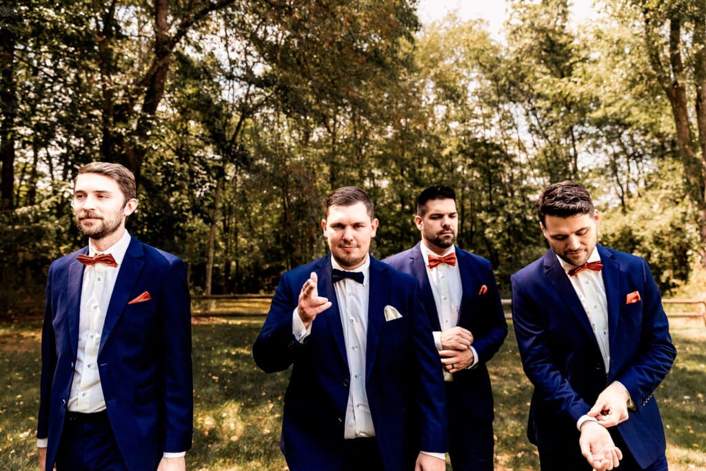 Groom and groomsmen walking and talking together at The Barn at Ever Thine wedding in Butler County, PA