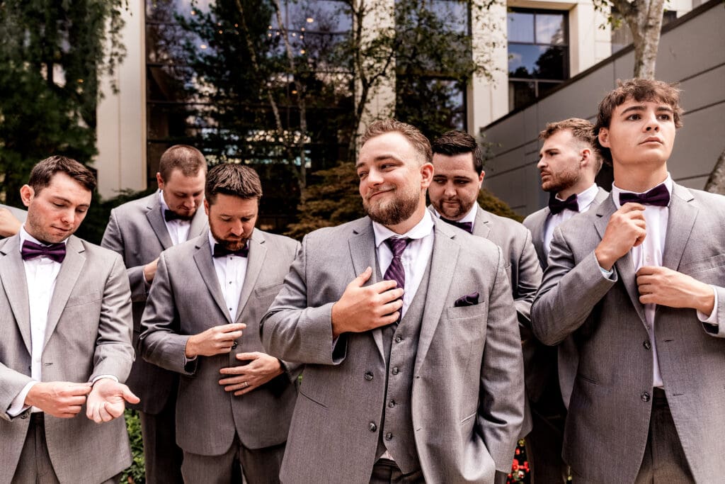 Pittsburgh groom smiling off camera as groomsmen pose at Pittsburgh Airport Marriott wedding