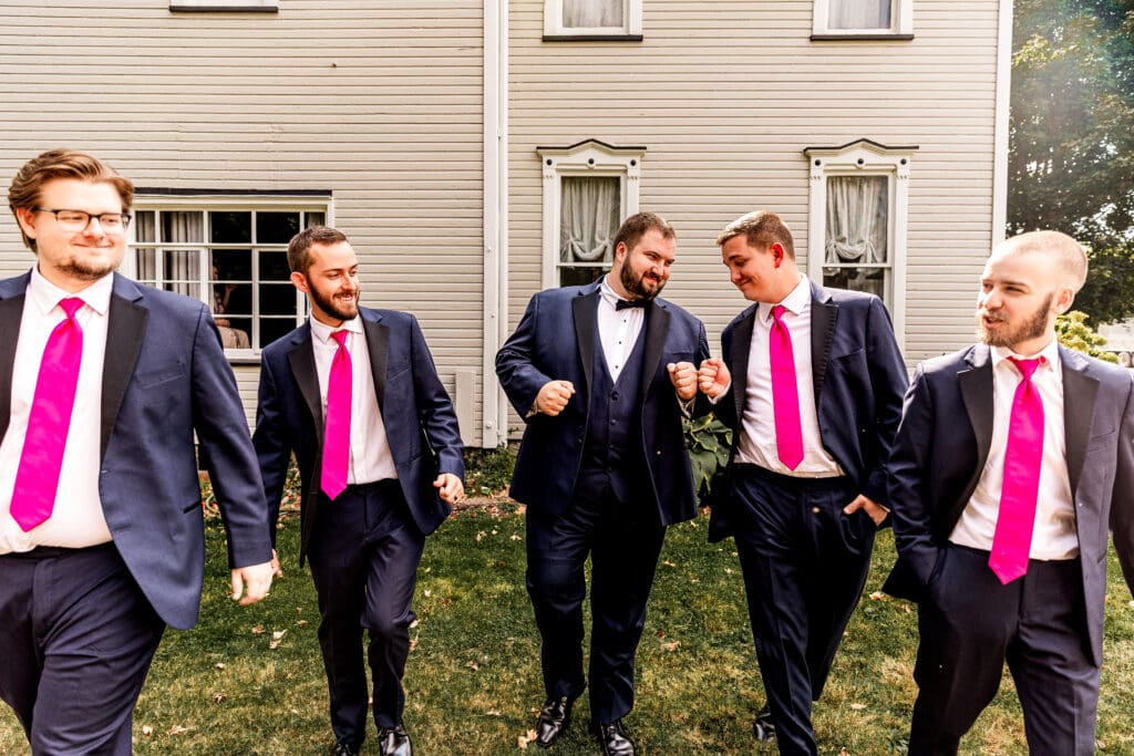 Groom and groomsmen walking toward the camera celebrating at The Gathering Place at Darlington Lake