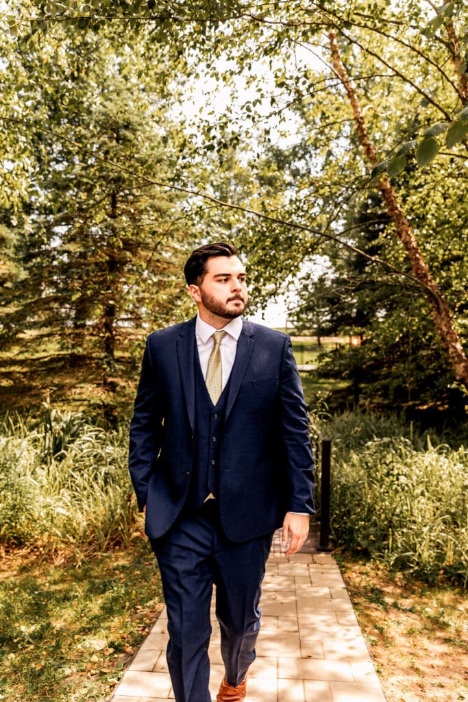 Pittsburgh groom walks toward the camera during wedding portraits at Willowbrook in Volant, PA